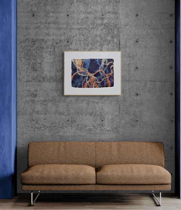 The painting inspired by the ficus trees in Valencia in a wooden frame, hanging on a concrete wall above a pale brown sofa.