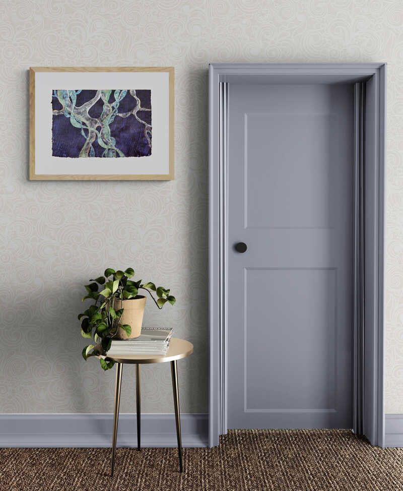 Abstract painting representing Posidonia Oceanica, a Mediterranean weed, framed and hanging on a wall, to the left of a grey door, above a coffee table with a plant on it.